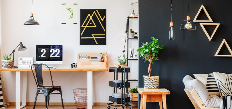 View of office area with modern furniture and accessories and charcoal grey accent wall in foreground